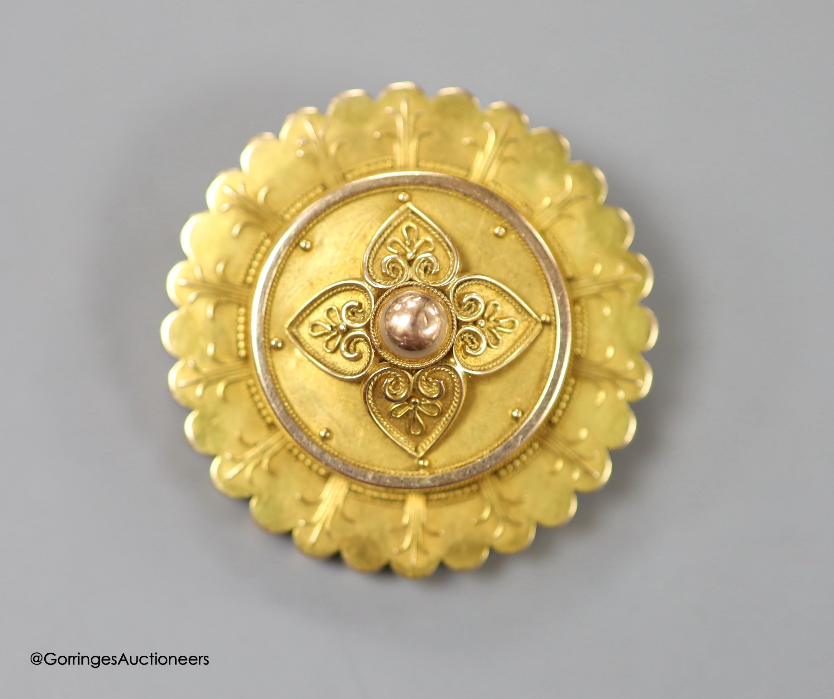 A Victorian yellow metal circular brooch, with central foliate motif, 38mm, gross 13.5 grams.